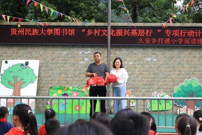 贵州民族大学图书馆副馆长龚剑向打通村小学校长谢以斌赠送图书